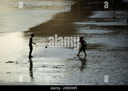 Zwei junge Männer spielen am späten Nachmittag am Strand von Rio Vermelho in Salvador, Bahia, Beachsoccer. Stockfoto