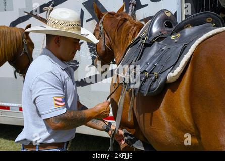 Sgt Vincent Aquino, ein Fort Carson Mountain Color Guard (FCMCG) Soldat, schnallt den Sattel an sein Pferd Sgt. Slim, zur Vorbereitung auf den nationalen Kalvarienwettbewerb 2022 auf dem historischen Wahrzeichen Fort Reno in El Reno, Okla., 20. September 2022. Der Nationale Kalvarienwettbewerb 2022 wird das erste Mal sein, dass dieses Team von FCMCG auf nationaler Ebene antreten wird. Stockfoto