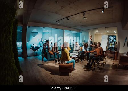 Eine schwanger Geschäftsfrau führt in einem modernen Coworking ein kreatives Treffen eines vielfältigen Business-Teams Stockfoto