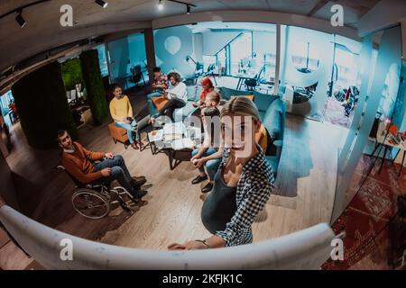Eine schwanger Geschäftsfrau führt in einem modernen Coworking ein kreatives Treffen eines vielfältigen Business-Teams Stockfoto
