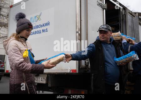 Cherson, Ukraine. 16.. November 2022. Eine Frau wird als humanitäre Hilfe angesehen, wenn sie Brot erhält. Die Bewohner von Kherson sind immer noch überglücklich über die Befreiung der Stadt und setzen mehr als 8 Monate der Besetzung zu Ende. Dennoch verfügt die südliche regionale Hauptstadt noch immer über keinen Strom, kein Wasser und ein Minimum an Signal- und Nahrungsmittelversorgung. Kredit: SOPA Images Limited/Alamy Live Nachrichten Stockfoto