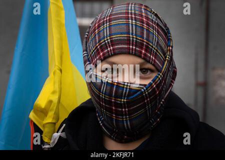 Cherson, Ukraine. 16.. November 2022. Ein Junge trägt eine ukrainische Flagge. Die Bewohner von Kherson sind immer noch überglücklich über die Befreiung der Stadt und setzen mehr als 8 Monate der Besetzung zu Ende. Dennoch verfügt die südliche regionale Hauptstadt noch immer über keinen Strom, kein Wasser und ein Minimum an Signal- und Nahrungsmittelversorgung. Kredit: SOPA Images Limited/Alamy Live Nachrichten Stockfoto