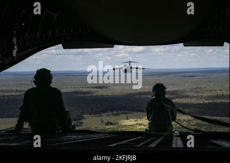 Der Royal Australian Air Force Corporal Shawn Harding, No. 36 Squadron Loadmaster, und der Senior Airman der US Air Force Jo Besse, Laderampler der 535. Airlift Squadron, sitzen auf der Rampe eines RAAF C-17 Globemaster III bei einem zweischiffigen Formationsflug während der Übung Globale Geschicklichkeit am Himmel über Queensland, 14. November 2022. Übung Global Dexterity 2022 wird auf der RAAF Base Amberley durchgeführt und soll dazu beitragen, die bilateralen taktischen Luftlift- und Lufttropfkapazitäten der United States Air Force (USAF) und der Royal Australian Air Force (RAAF) zu entwickeln. Sowohl die Vereinigten Staaten als auch Australien vertrauen darauf Stockfoto