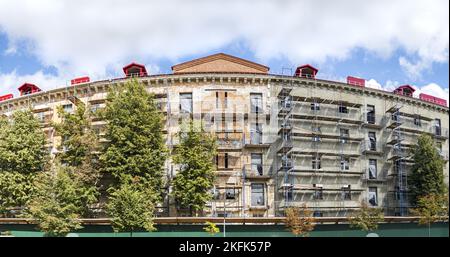 Renovierung von Wohngebäuden. Restaurierung einer alten Gebäudefassade. Gerüste auf der Baustelle. Stockfoto