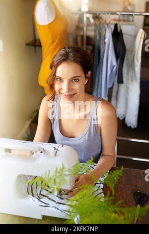 Kreativität geht nie aus dem Stil. Eine junge Designerin, die an ihrem Arbeitsplatz ein Kleidungsstück herstellt. Stockfoto