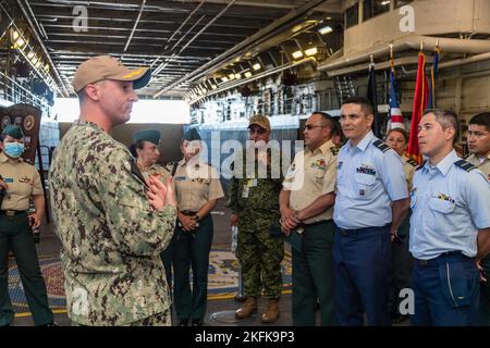 220922-N-VQ947-1017 SAN DIEGO (SEPT. 22, 2022) – U.S. Navy Cmdr. Johnath Stinnette, links, Executive Officer an Bord der Amphibienstation USS Portland (LPD 27), begrüßt Besucher des Kolumbianischen Kriegskollegs, 22. September 2022. Portland ist ein Amphibientransportsdock der San Antonio-Klasse, das in San Diego heimisch ist. Stockfoto