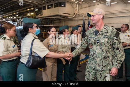 220922-N-VQ947-1012 SAN DIEGO (SEPT. 22, 2022) – U.S. Navy Cmdr. Johnath Stinnette, rechts, Executive Officer an Bord der Amphibienstation USS Portland (LPD 27), begrüßt Besucher des Kolumbianischen Kriegskollegs, 22. September 2022. Portland ist ein Amphibientransportsdock der San Antonio-Klasse, das in San Diego heimisch ist. Stockfoto