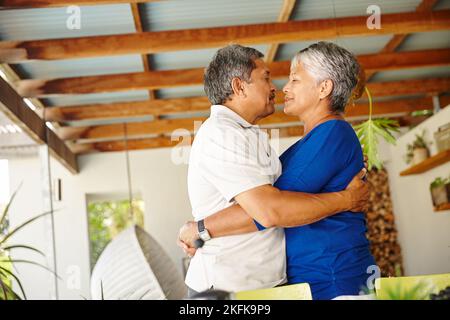 Ich liebe dich, Honig. Ein glückliches Seniorenpaar, das zu Hause in eine warme Umarmung gehüllt ist. Stockfoto