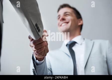 Sie sind perfekt für unser Business-Team. Low-Angle-Aufnahme von zwei Geschäftsleuten, die sich die Hände schüttelten. Stockfoto
