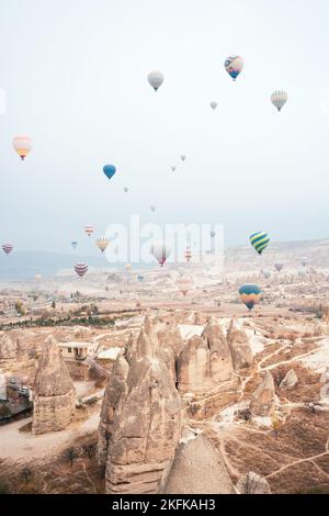 Atemberaubende Aussicht einige Heißluftballons fliegen über die wunderschöne Landschaft von Kappadokien an einem bewölkten Tag. Goreme, Zentrum von Antolien, Türkei. Stockfoto