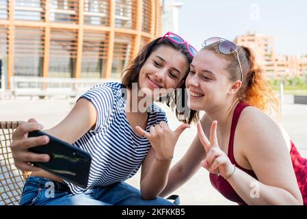 Zwei junge Frauen, die ein Selfie machen, ein paar Touristenmädchen in der Stadt Stockfoto