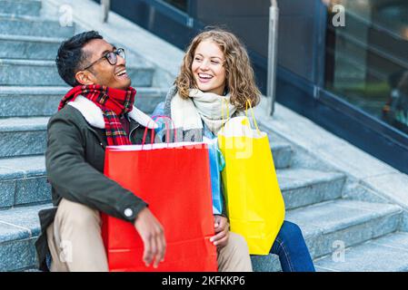 Junge Frau sucht ihre Freunde, multirassische Paar in der Liebe einkaufen gehen Stockfoto