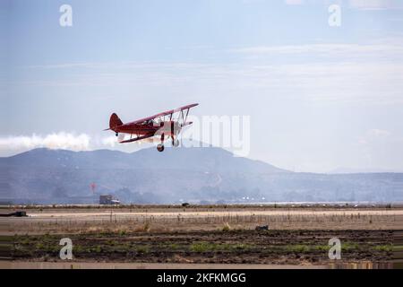 Vicky Benzing, die ihre Boeing-Stearman Model 75 1940 pilotiert, führt Kunstflug während der Miramar Air Show 2022 der Marine Corps Air Station im MCAS Miramar, San Diego, Kalifornien, am  . September 2022 durch. Benzing tritt seit 2005 bei Kunstflug-Wettbewerben an und fliegt auf Flugshows. Das Thema der MCAS Miramar Air Show 2022 „Marines Fight, Evolve and Win“ spiegelt die fortlaufenden Modernisierungsbemühungen des Marine Corps wider, um sich auf zukünftige Konflikte vorzubereiten. Stockfoto