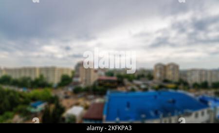 Abstrakter Blick auf die Stadt mit bewölktem Himmel, Blick von der Terrasse des Luxusapartments des Hotels. Verwackelte Hintergrundansicht vom Balkon nach Stockfoto