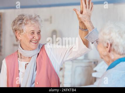 Ältere Frauen, hohe fünf und Freunde glücklich, feiern und glücklich zusammen im Altersheim, Partnerschaft und Unterstützung. Ältere Frauen, Motivation und Stockfoto