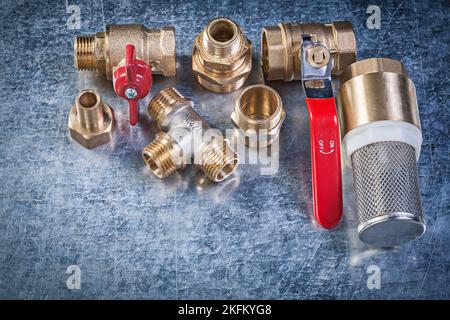 Messing Hebel Kugelhahn Rohrverbinder Sieb Filter auf metallischen Hintergrund Sanitär-Konzept. Stockfoto