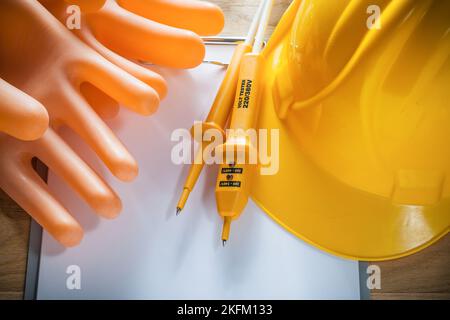 Clipboard Papier isolierende Handschuhe Harthut Elektro-Tester auf Holzbrett. Stockfoto