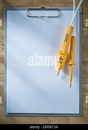 Klemmbrett Papier elektrische Tester auf Holzbrett. Stockfoto