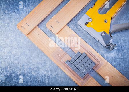 Sammlung von Hefter Pistole Metall Klammern Holzbauplatte auf metallischem Hintergrund. Stockfoto