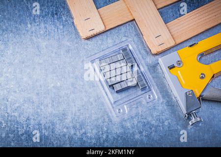 Sammlung von Hefter Pistole Metall Klammern Holzbrett auf metallischem Hintergrund. Stockfoto