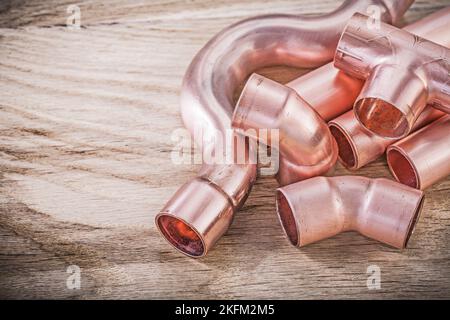 Kupfer-Wasserrohr-Steckverbinder auf Holzbrett Sanitär-Brassware-Konzept. Stockfoto