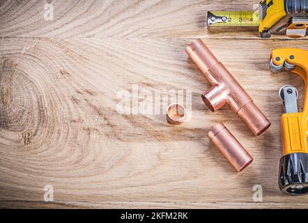 Kupfer Wasserrohr Cutter Steckverbinder Band Linie auf Holzbrett kopieren Raum Sanitär Brassware Konzept. Stockfoto