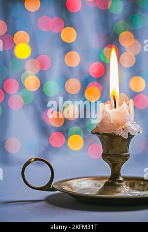 Copyspace Bild Vintage Kerzenständer mit brennender Kerze auf dem Hintergrund von abstraktem Bokeh Stockfoto