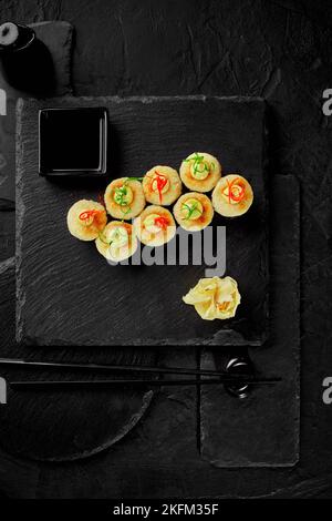 Gebackenes Maki-Sushi mit geschmolzenem Käse, serviert mit Gari und Sojasauce Stockfoto