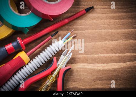 Isolierband für elektrische Drähte mit Wellrohr und isoliertem Schraubendreher, Schneidzange. Stockfoto