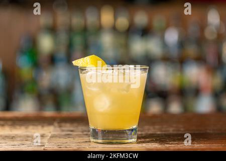 Penicillin-Cocktail an der Bar. Verschwommener Hintergrund.erfrischendes Getränk im Sommer, Seitenansicht, Nahaufnahme. Stockfoto