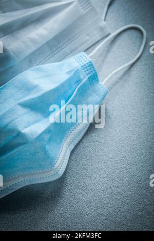 Sterile Einweg-Gesichtsmasken auf grauem Hintergrund. Stockfoto
