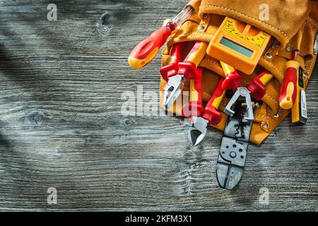 Elektrische Werkzeuge in Leder Werkzeuggürtel auf Vintage-Holz Hintergrund gesetzt Stockfoto