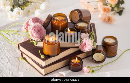 Ein Set verschiedener Duftkerzen in braunen Glasgefäßen. Handgemachte Duftkerze. Sojalkerzen brennen in einem Glas. Aromatherapie und entspannen Sie sich im Spa und zu Hause. Feuer in braunem Glas. Stockfoto