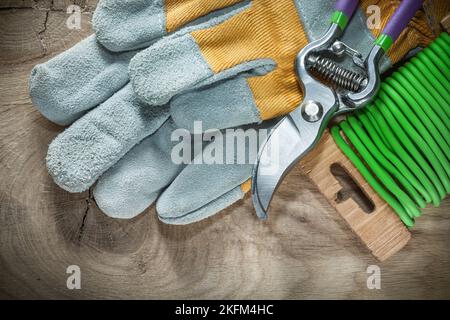 Gartenscheren Garten weiche Twist Krawatte Schutzhandschuhe auf Holzbrett. Stockfoto