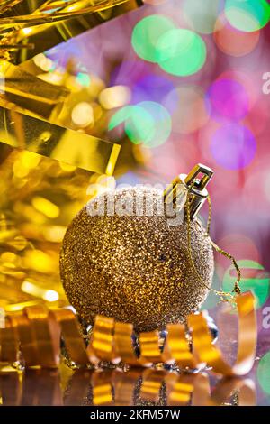 Goldfarbener weihnachtsball mit Schnur auf dem Hintergrund von Bokeh Stockfoto