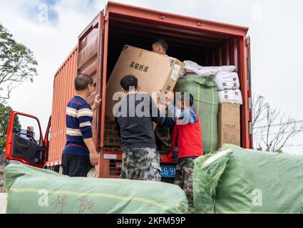 (221119) -- HONGHE, 19. November 2022 (Xinhua) -- Waldhüter und Freiwillige überweisen Hilfsgüter für Erdbebenhilfe in das Dorf Anpin der Gemeinde Langdi, Bezirk Honghe, südwestlich der Provinz Yunnan, 19. November 2022. Ein Erdbeben der Stärke 5,0 erschütterte den Bezirk Honghe in den autonomen Präfekturen Honghe Hani und Yi, südwestlich der Provinz Yunnan, am Samstag (Pekinger Zeit) um 1:27 Uhr, wie das China Earthquake Networks Center (CENC) mitteilte. In den vom Beben betroffenen Bereichen wurden Hausschäden, wie eingestürzte Fliesen und Wandrisse, gemeldet, aber es wurden keine Menschenopfer gefunden, wie aus einem zu entnehmen ist Stockfoto