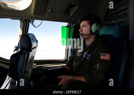 Capt. Neil Brown, 301. Airlift Squadron C-17 Globemaster III Pilot, blickt aus dem Fenster eines C-17 Globemaster III am 24. September 2022. Der 349. Air Mobility Wing führte eine dreitägige Mission durch, um humanitäre Fracht nach Haiti zu transportieren. Im Rahmen des Denton-Programms wurden drei Schulbusse, die vom San Diego Unified School District gespendet wurden, von der March Air Reserve Base, Kalifornien, nach Haiti transportiert. Stockfoto