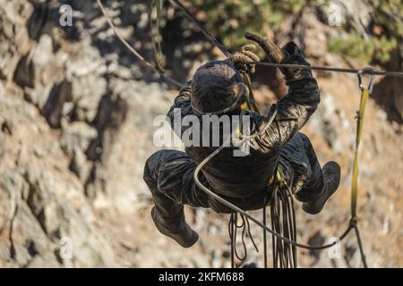 U.S. Navy Petty Officer 3. Class Shaun Mason, ein Krankenhauskorpsman mit Echo Company, 2. Bataillon, 1. Marine Regiment, 1. Marine Division, zieht sich während der Bergtrainingsübung 1-23 im Marine Corps Mountain Warfare Training Center Bridgeport, Kalifornien, 25. September 2022 mit der Hand über eine Zipline. Während der MTX lernten die Marines verschiedene Fähigkeiten, um in einer strengen Bergumgebung besser im Kampf und Überleben zu sein. Stockfoto