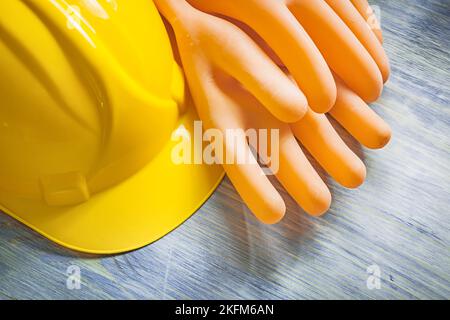 Isolierhandschuhe Bau Helm auf Holzbrett Strom-Konzept. Stockfoto