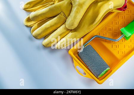 Schutzhandschuhe aus Leder lackieren Tray Roller auf weißem Hintergrund. Stockfoto