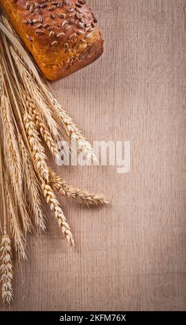 Brot aus braunem Brot mit Weizenohren auf Holzeiche Brett Essen und Trinken Konzept Stockfoto