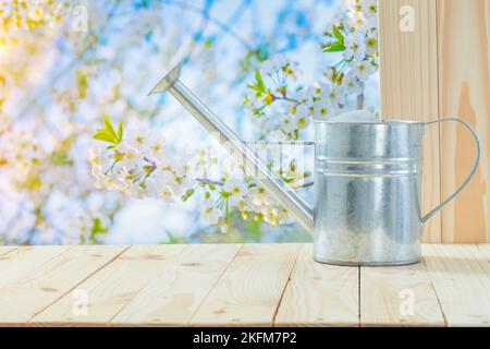 Metallic-Wasser-Dose auf dem Tisch im Garten Stockfoto