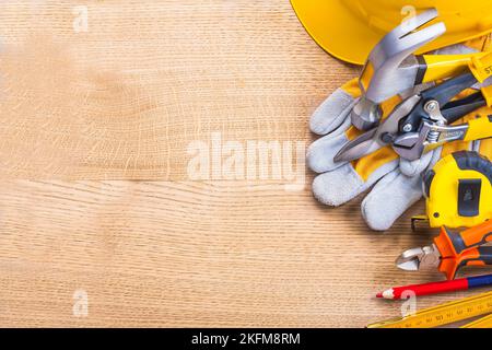 Organisiert Copyspace großen Satz von Werkzeugen Meter Bleistift Zangen tapeline Schlüssel Cutter Hammer Handschuh Helm auf Holzbrett Stockfoto