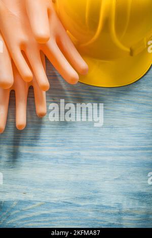 Zwei dielektrische Handschuhe bauen Helm auf Holzbrett Strom Konzept. Stockfoto