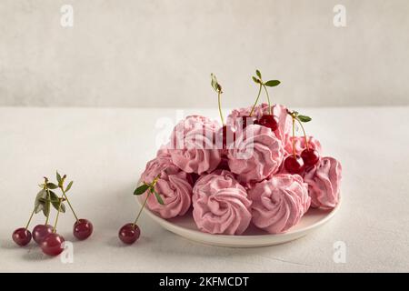 Köstliche süße zephyr und Kirschen auf hellem Hintergrund, das Konzept einer gesunden und gesunden Eigenproduktion. Stockfoto