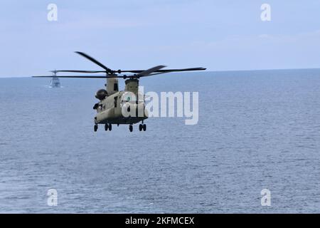 Soldaten der B Company, 3-2 General Support Aviation Bataillon, 2. die Combat Aviation Brigade führte am 26. September 2022 Decklandungen mit CH-47F Chinook-Hubschraubern auf dem einzigen vorwärts eingesetzten Flugzeugträger der US-Marine, USS Ronald Reagan (CVN 76), in den Gewässern östlich der koreanischen Halbinsel durch. Die Qualifikation für die Landung an Deck wird durchgeführt, um die Mitglieder der Luftbesatzung und Piloten bei der Landung auf einem Schiff zu zertifizieren. Diese Schulung wurde im Rahmen der Maritime Counter Special Operations Exercise (MCSOFEX) durchgeführt, um die Interoperabilität mit unseren gemeinsamen Partnern zu stärken. Stockfoto
