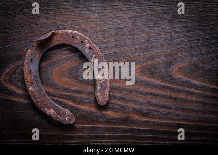 Verrostete veraltete Hufeisen auf vintage dunklem Holzbrett kopieren Raum Bild Konstruktion Konzept. Stockfoto