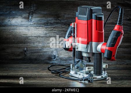 Seitenansicht rot Geschwindigkeit variable Leistung kleine Tauchfräse Fräsmaschine tragbare elektrische Hand Mini Holz Router auf Vintage Holz Stockfoto