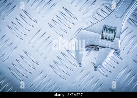 Edelstahl-Affenschlüssel auf Wellblech Draufsicht Konstruktionskonzept. Stockfoto