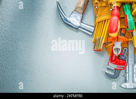 Werkzeuggürtel Konstruktionswerkzeuge auf Beton Hintergrund. Stockfoto